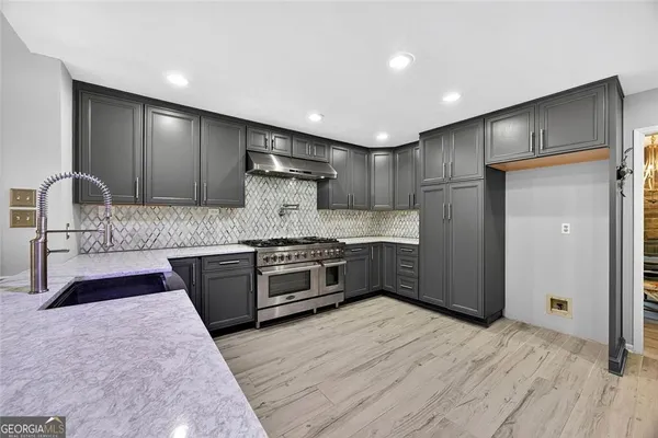 a large kitchen with stainless steel appliances kitchen island granite countertop a stove a sink and a refrigerator