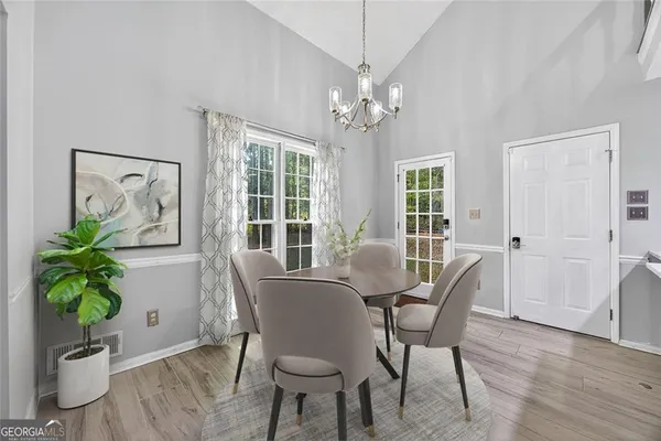 a view of a dining room with furniture a potted plant and wooden floor