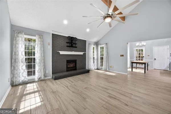 a view of empty room with wooden floor and a fireplace