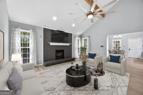 a living room with furniture a flat screen tv and a fireplace