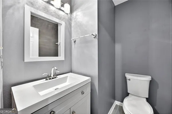 a bathroom with a toilet sink and mirror
