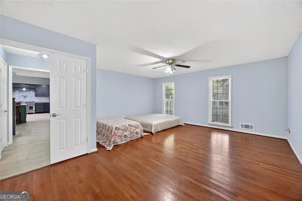 a view of a livingroom with wooden floor and a ceiling fan