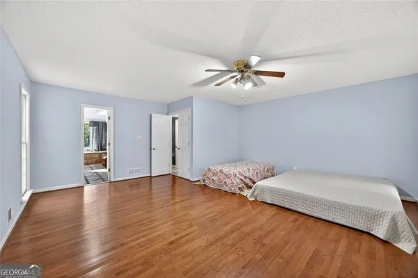 a living room with couches and ceiling fan with wooden floor
