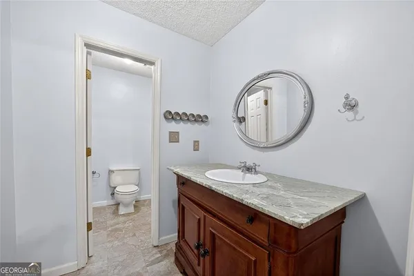 a bathroom with a granite countertop sink and a mirror