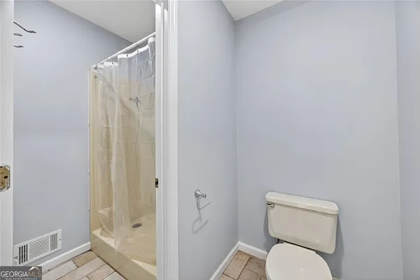 a white toilet sitting next to a shower