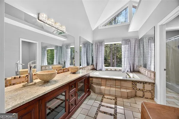 a bathroom with double vanity and a bathtub
