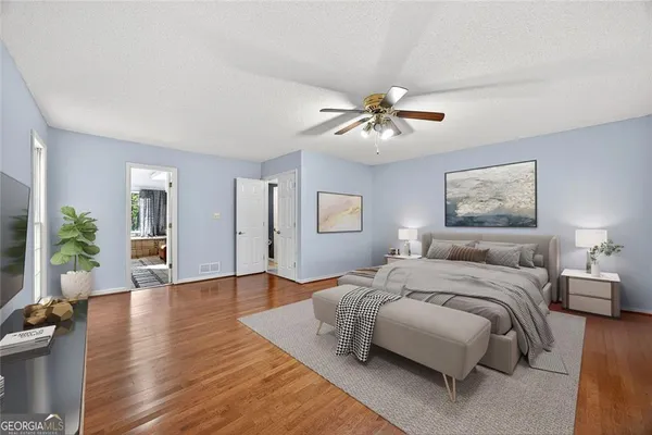 a spacious bedroom with a large bed a chandelier and a couch