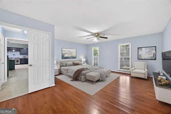 a spacious bedroom with a bed and wooden floor
