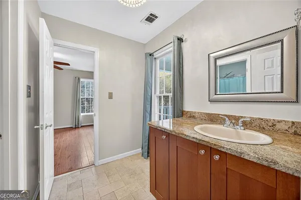 a bathroom with a granite countertop sink and a mirror