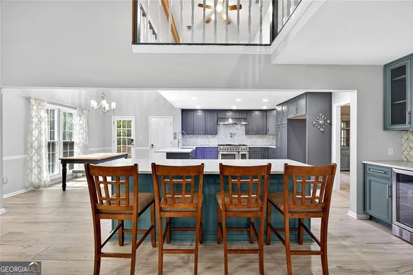 a dining hall with stainless steel appliances kitchen island a table and chairs
