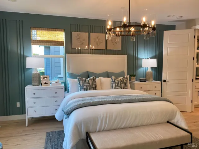 a bedroom with a bed a large mirror and a chandelier