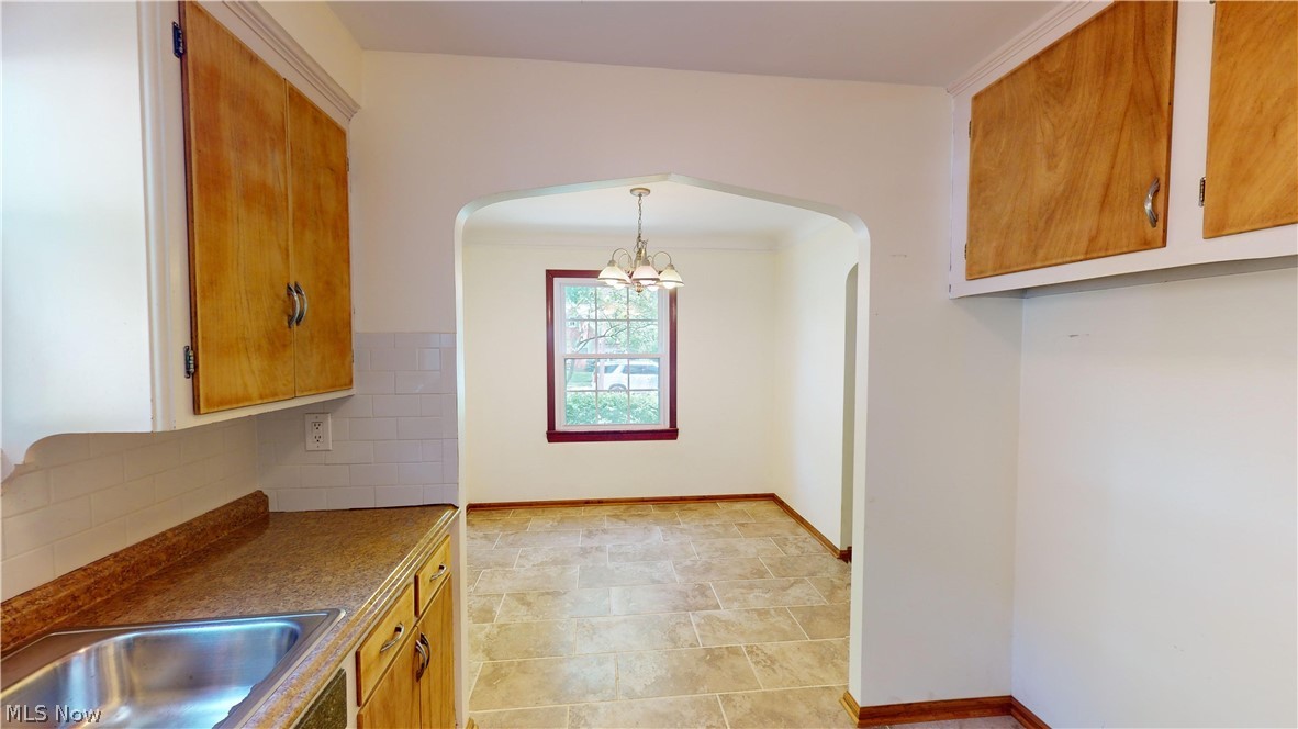 4334 West Anderson Road South Euclid, OH 44121 - Photo 3 of 12 Kitchen with decorative light fixtures, an inviting chandelier, backsplash, and light tile floors