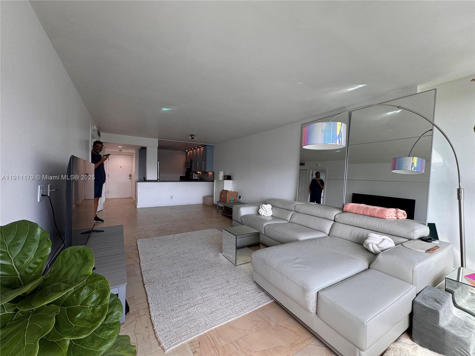 8233 Harding Avenue, Unit 403 Miami Beach, FL 33141 - Photo 11 of 11 a living room with furniture and a flat screen tv