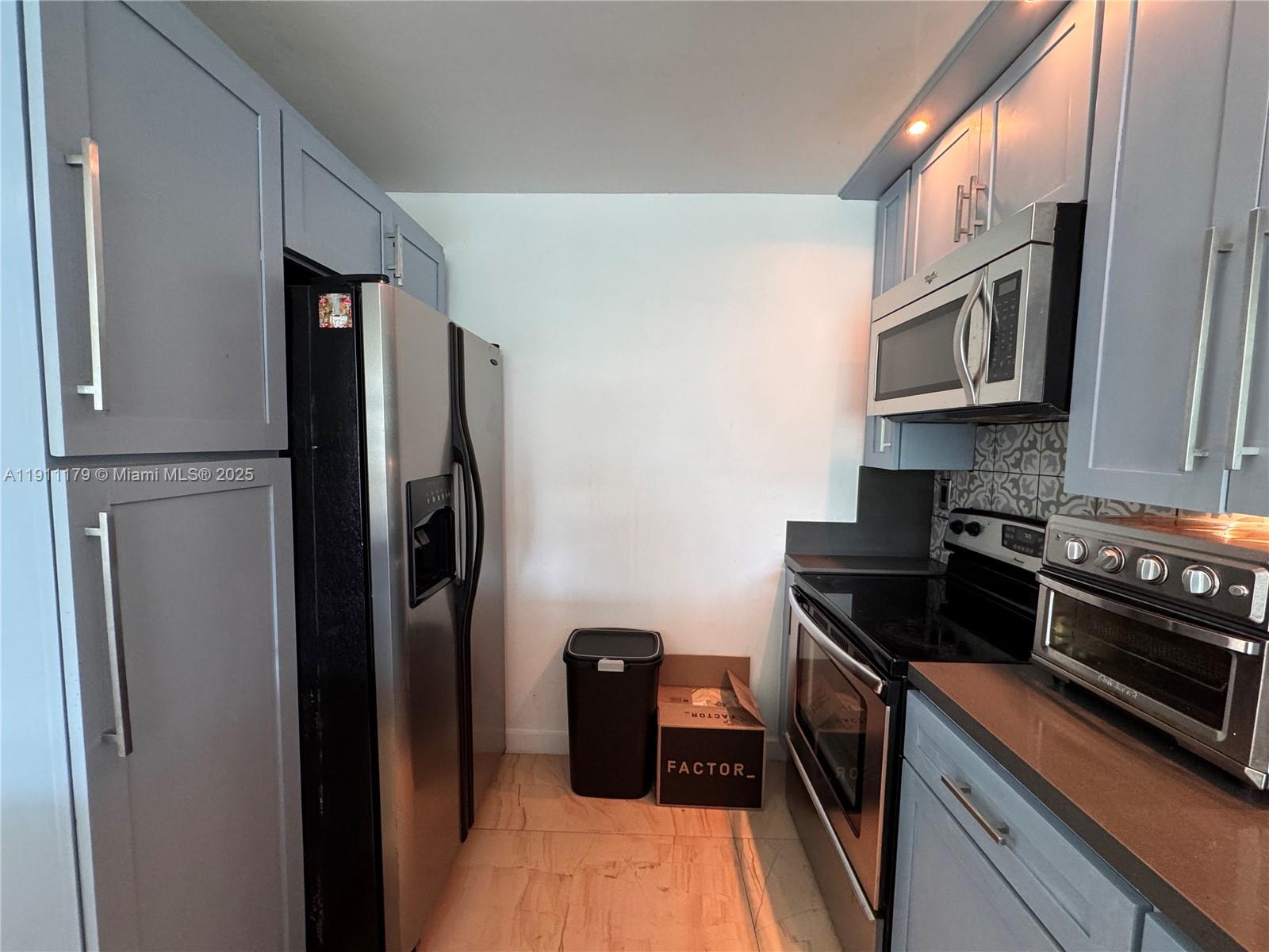 8233 Harding Avenue, Unit 403 Miami Beach, FL 33141 - Photo 4 of 11 a kitchen with stainless steel appliances granite countertop a refrigerator a stove and a sink