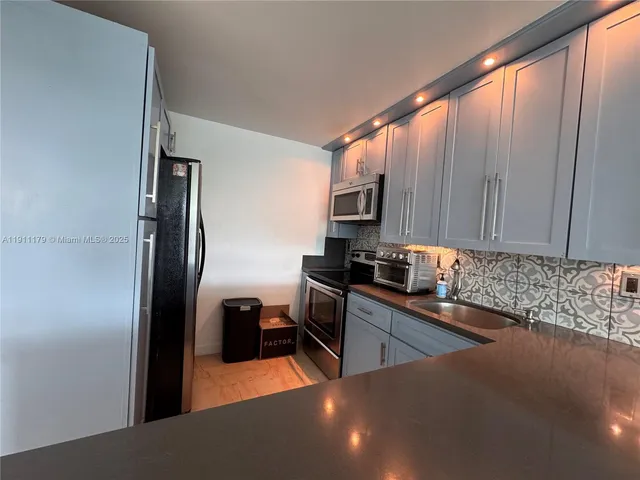 a kitchen with stainless steel appliances a sink a stove and a refrigerator