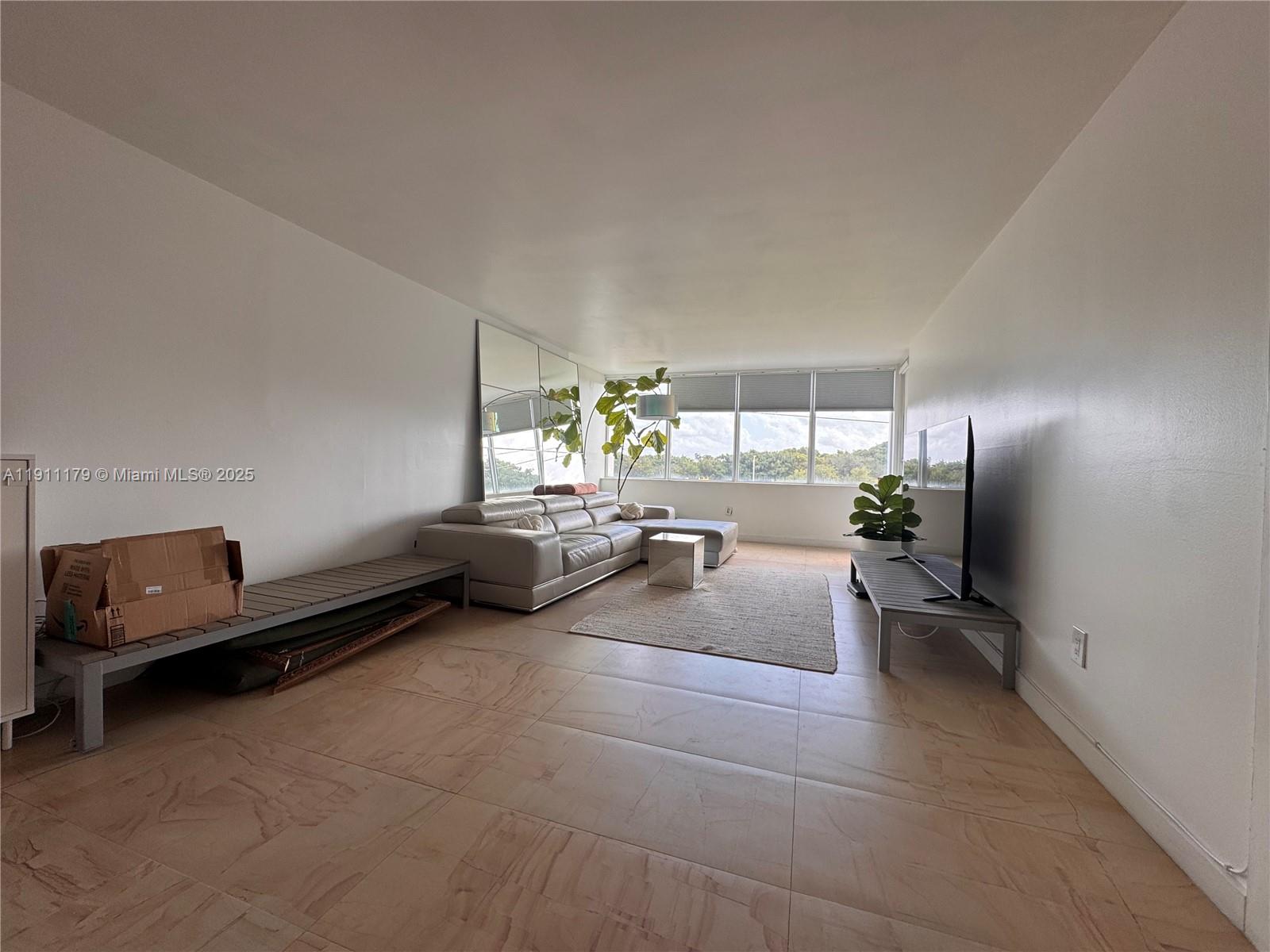 8233 Harding Avenue, Unit 403 Miami Beach, FL 33141 - Photo 6 of 11 a living room with furniture and a window