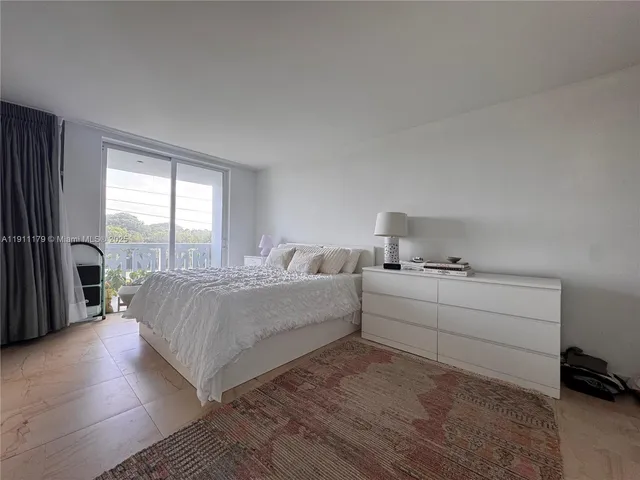 a living room with a bed furniture and a large window