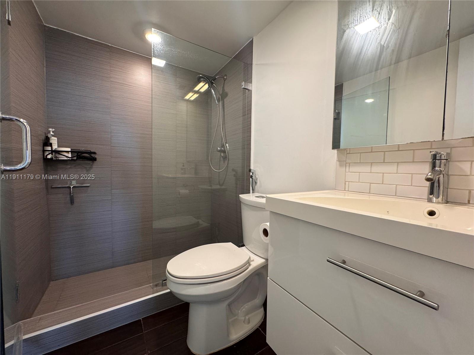 8233 Harding Avenue, Unit 403 Miami Beach, FL 33141 - Photo 8 of 11 a bathroom with a sink a toilet and shower