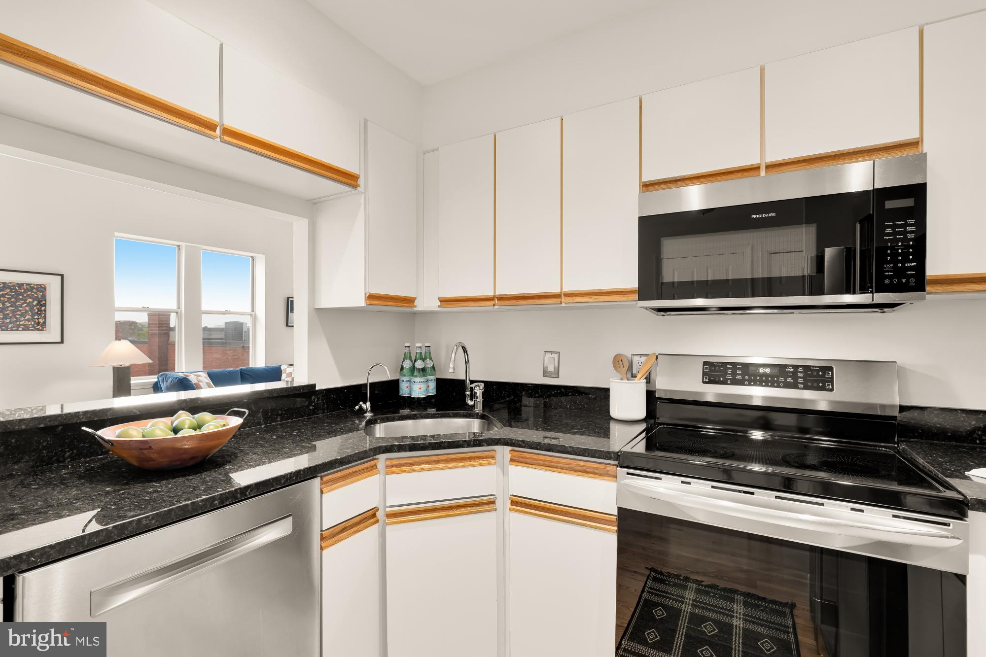 1619 R Street Northwest, Unit 606 Washington, DC 20009 - Photo 11 of 25 a kitchen with stainless steel appliances granite countertop a sink a stove a microwave and cabinets