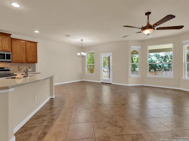 a living room with couches a dining table and chandelier