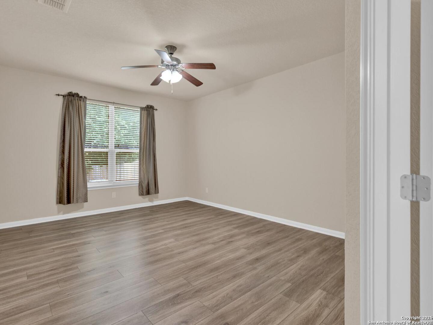 1008 Magellan Windcrest, TX 78239 - Photo 16 of 31 a view of an empty room with wooden floor and a window