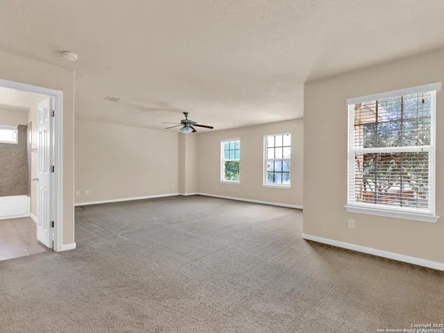 a view of an empty room and a ceiling fan