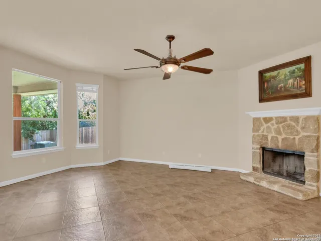 an empty room with windows and fireplace