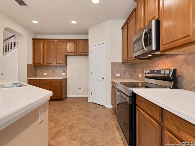 a kitchen with a sink stove and cabinets