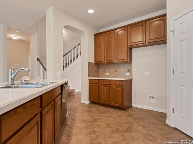 a large kitchen with stainless steel appliances wooden cabinets and a sink