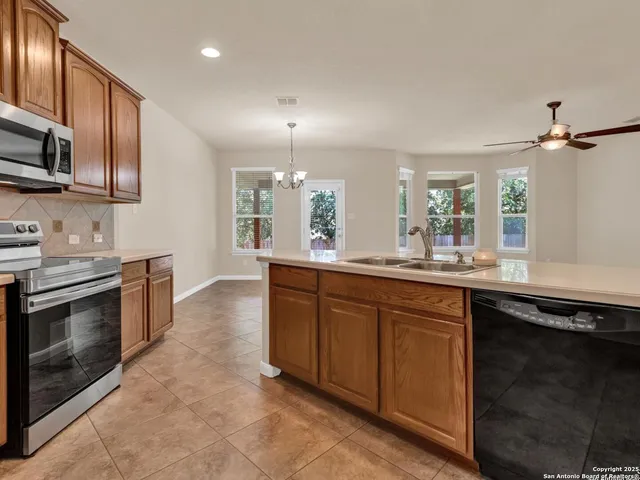 a kitchen with stainless steel appliances granite countertop a stove a sink and a microwave