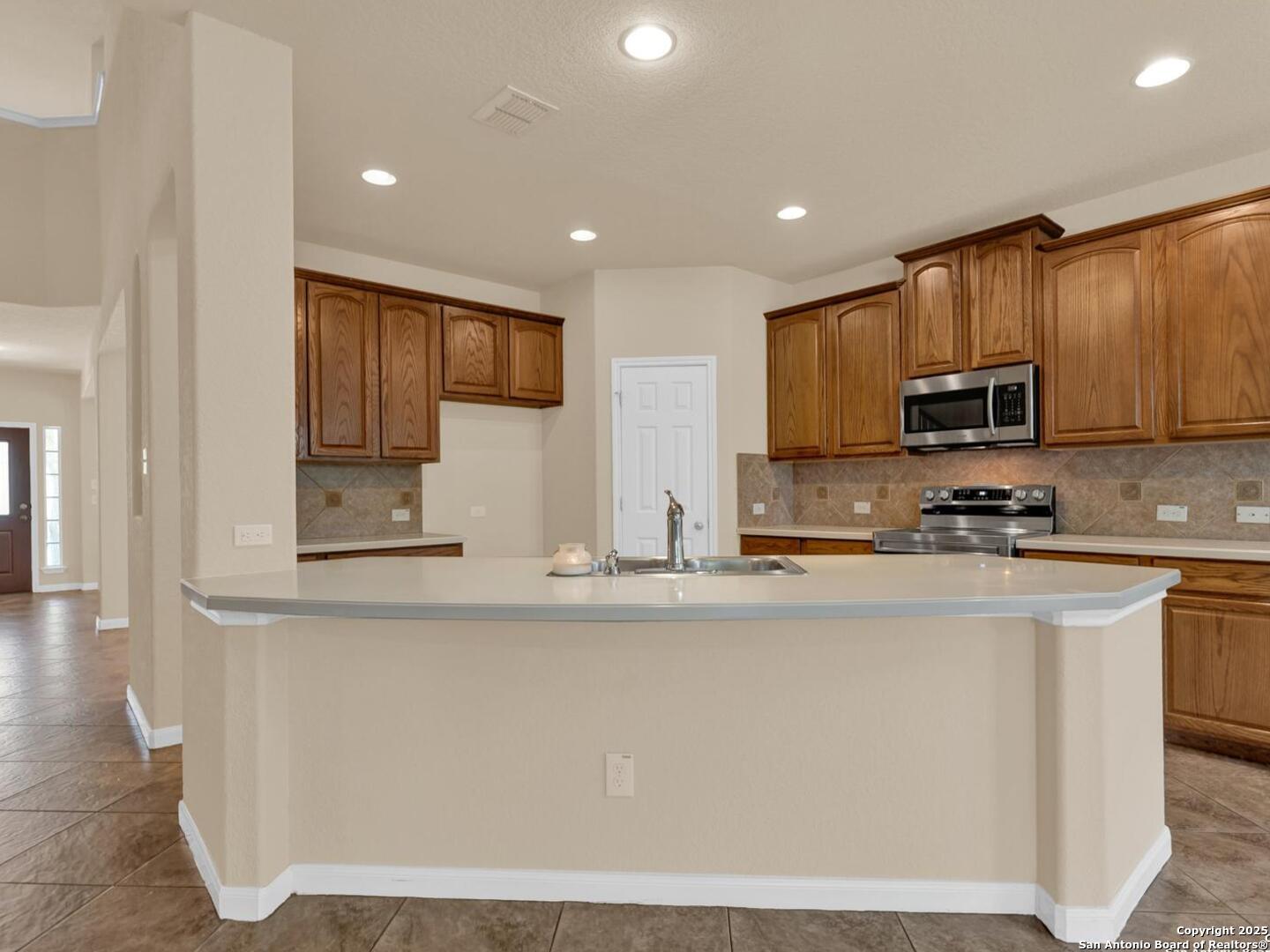 1008 Magellan Windcrest, TX 78239 - Photo 10 of 31 a kitchen with stainless steel appliances granite countertop a stove a sink and a microwave