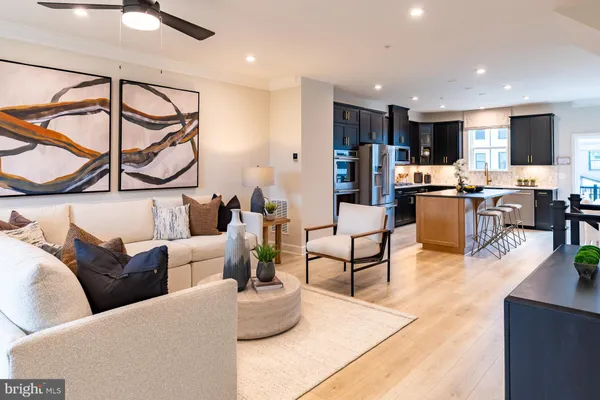 a living room with furniture kitchen view and a flat screen tv