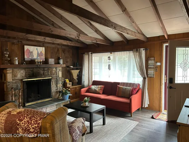 a living room with furniture a fireplace and a wooden floor