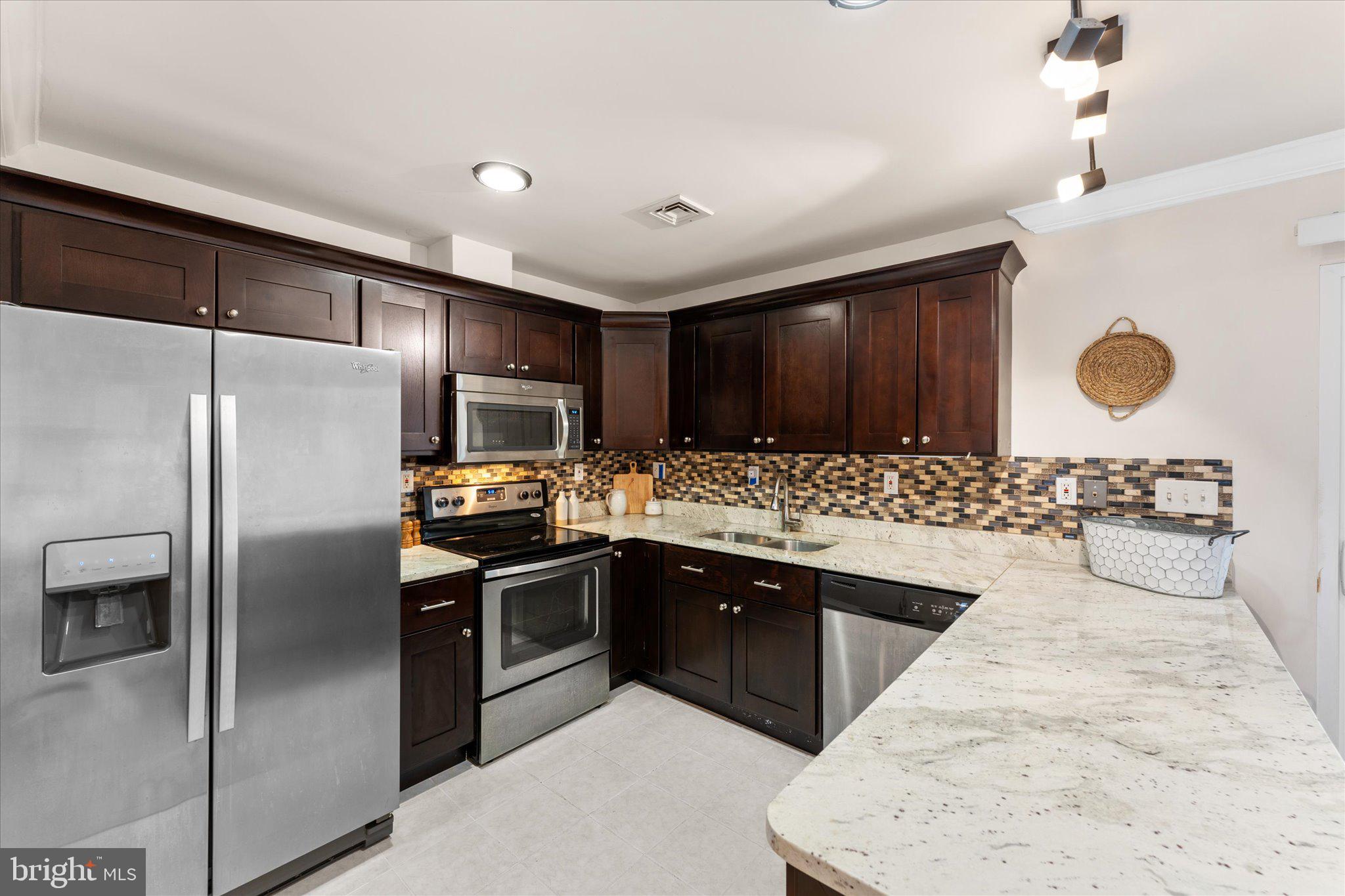 2231 Southgate Square Reston, VA 20191 - Photo 11 of 36 a kitchen with stainless steel appliances granite countertop a sink and refrigerator