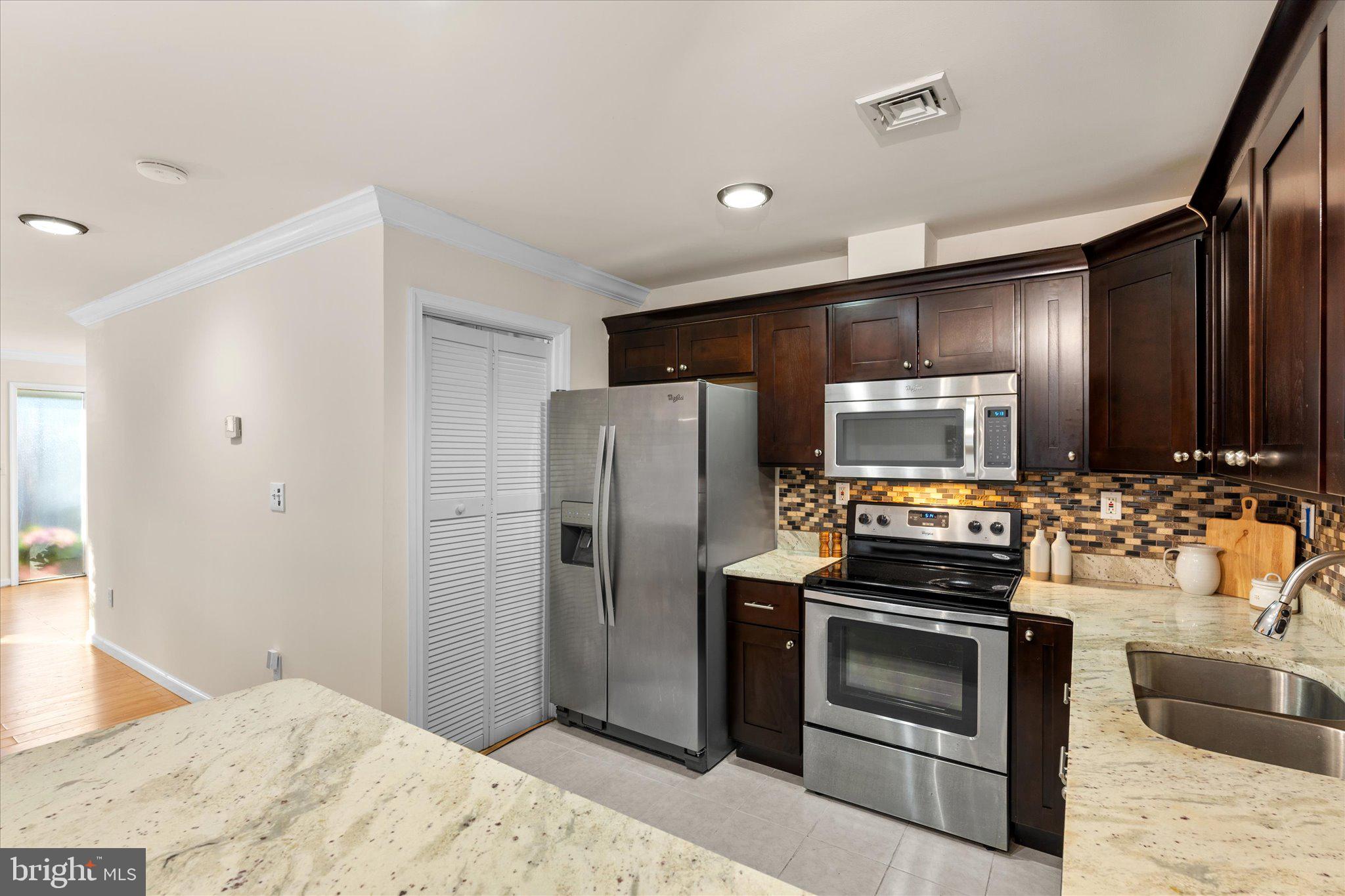 2231 Southgate Square Reston, VA 20191 - Photo 13 of 36 a kitchen with stainless steel appliances kitchen island granite countertop a refrigerator stove and sink