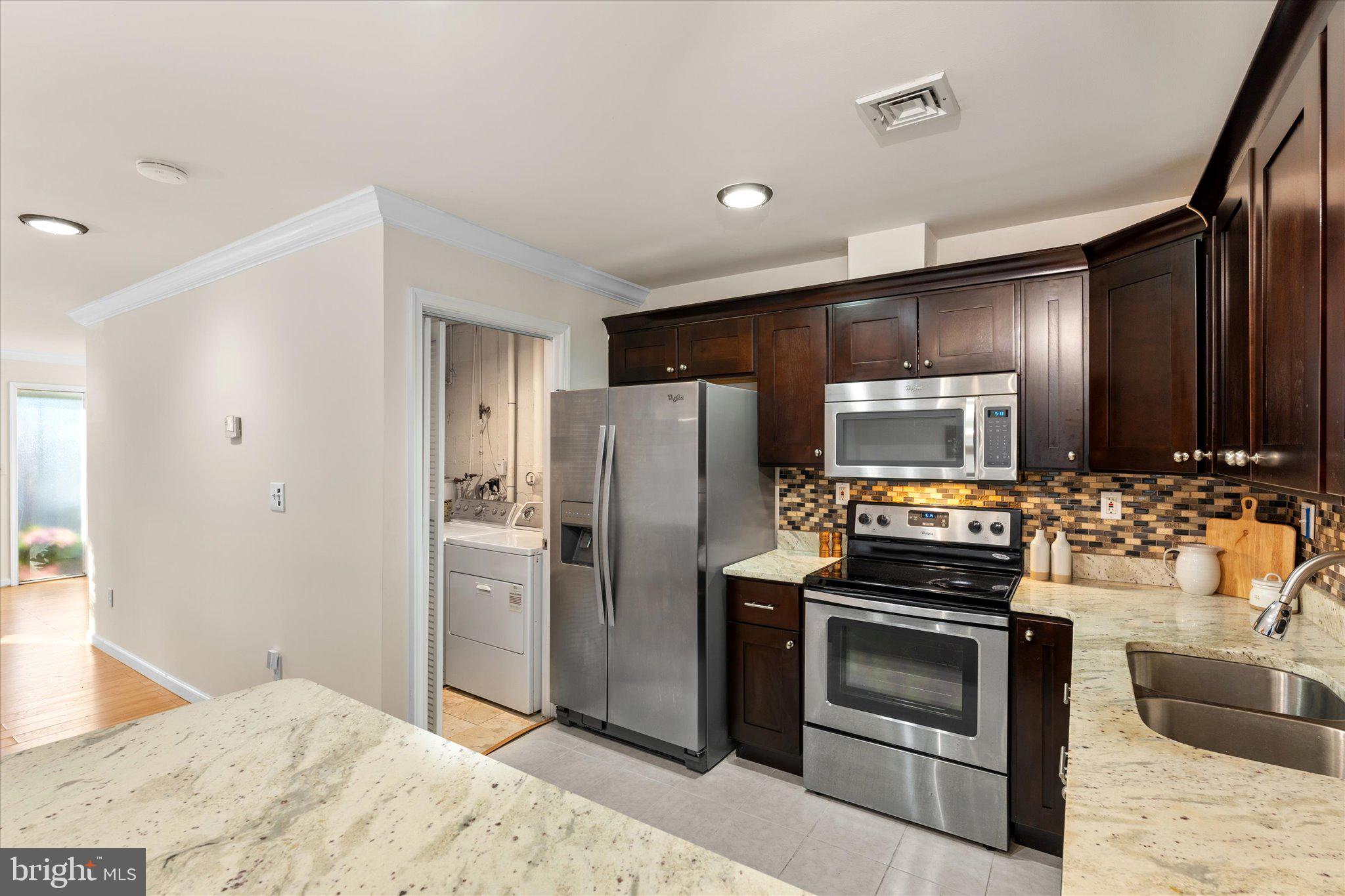 2231 Southgate Square Reston, VA 20191 - Photo 14 of 36 a kitchen with stainless steel appliances kitchen island granite countertop a refrigerator stove and sink