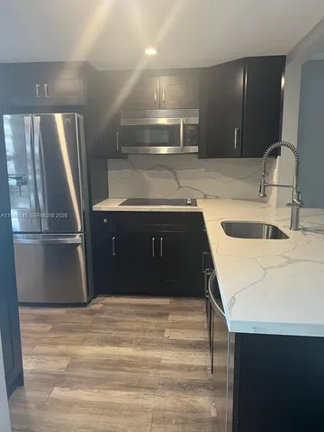 a kitchen with a sink and a refrigerator