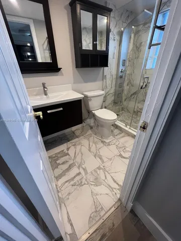 a bathroom with a toilet a sink and mirror