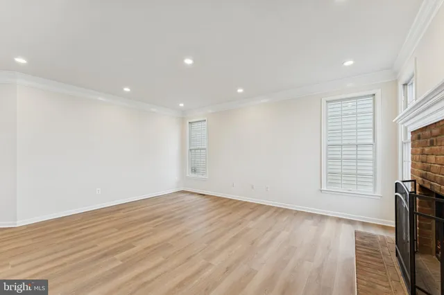 a view of empty room with wooden floor and fireplace