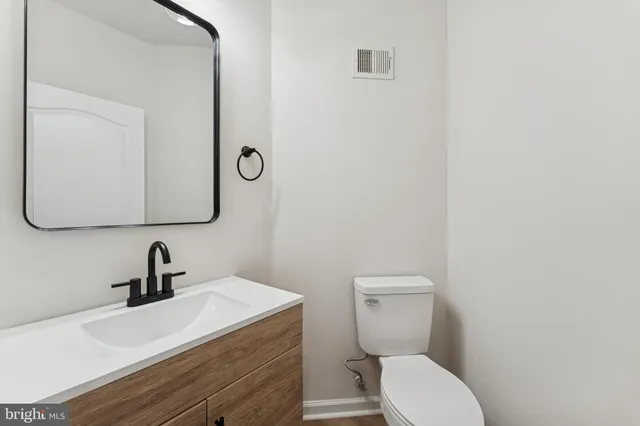 a bathroom with a toilet a sink and mirror