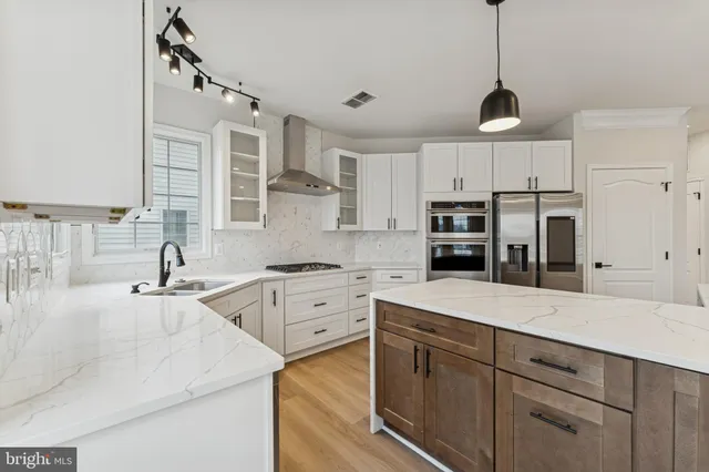 a kitchen with stainless steel appliances kitchen island granite countertop a sink stove and refrigerator