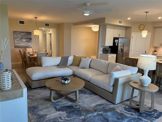 a living room with furniture and a dining table with kitchen view