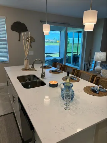 a kitchen with a sink a counter and a dining table