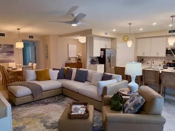 a living room with furniture wooden floor and a kitchen view
