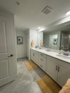 a spacious bathroom with a double vanity sink and mirror