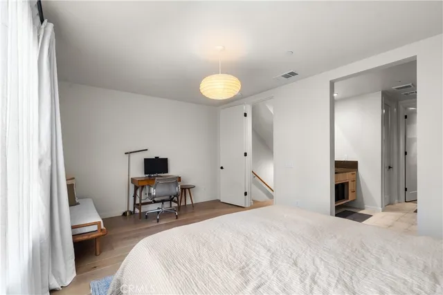 a spacious bedroom with a bed and a chandelier