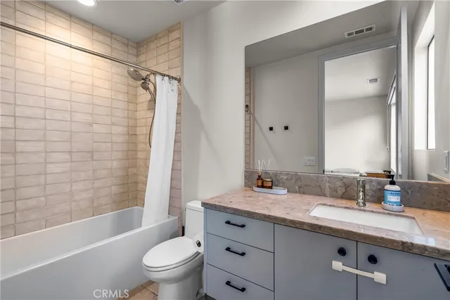 a bathroom with a granite countertop sink a toilet and shower