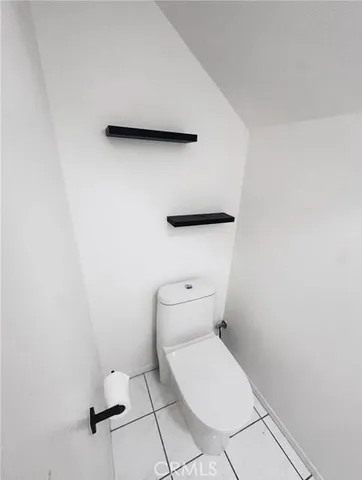 a white toilet sitting next to a white cabinet