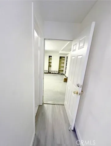 a view of a hallway with wooden floor and stairs