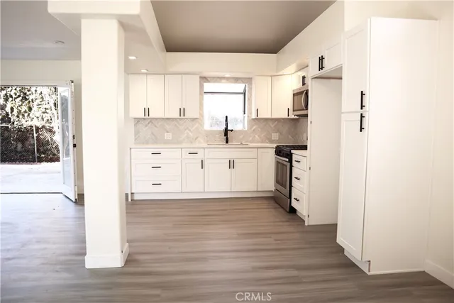a kitchen with stainless steel appliances granite countertop a refrigerator and a stove top oven